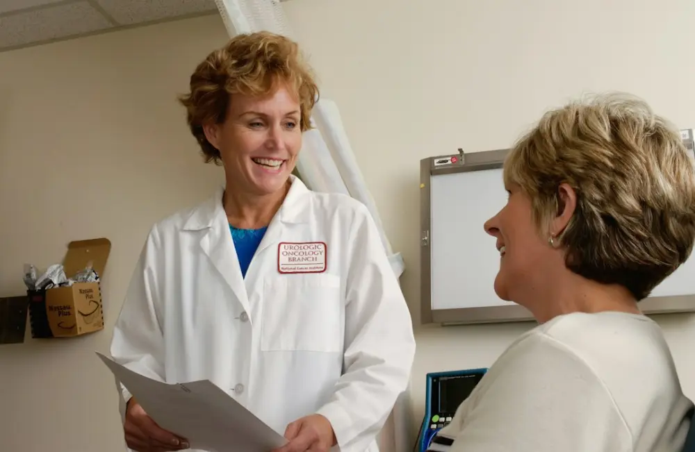 A smiling doctor in a white coat talking to a patient in a clinic, illustrating questions to ask before restrictive dietary
